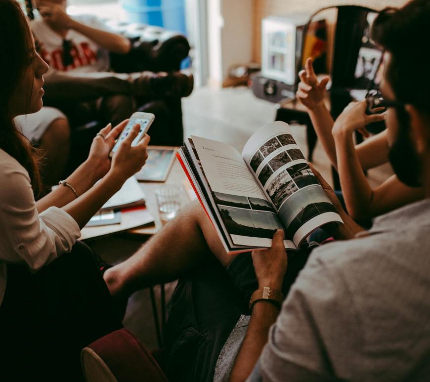 group of people reading book sitting on chair